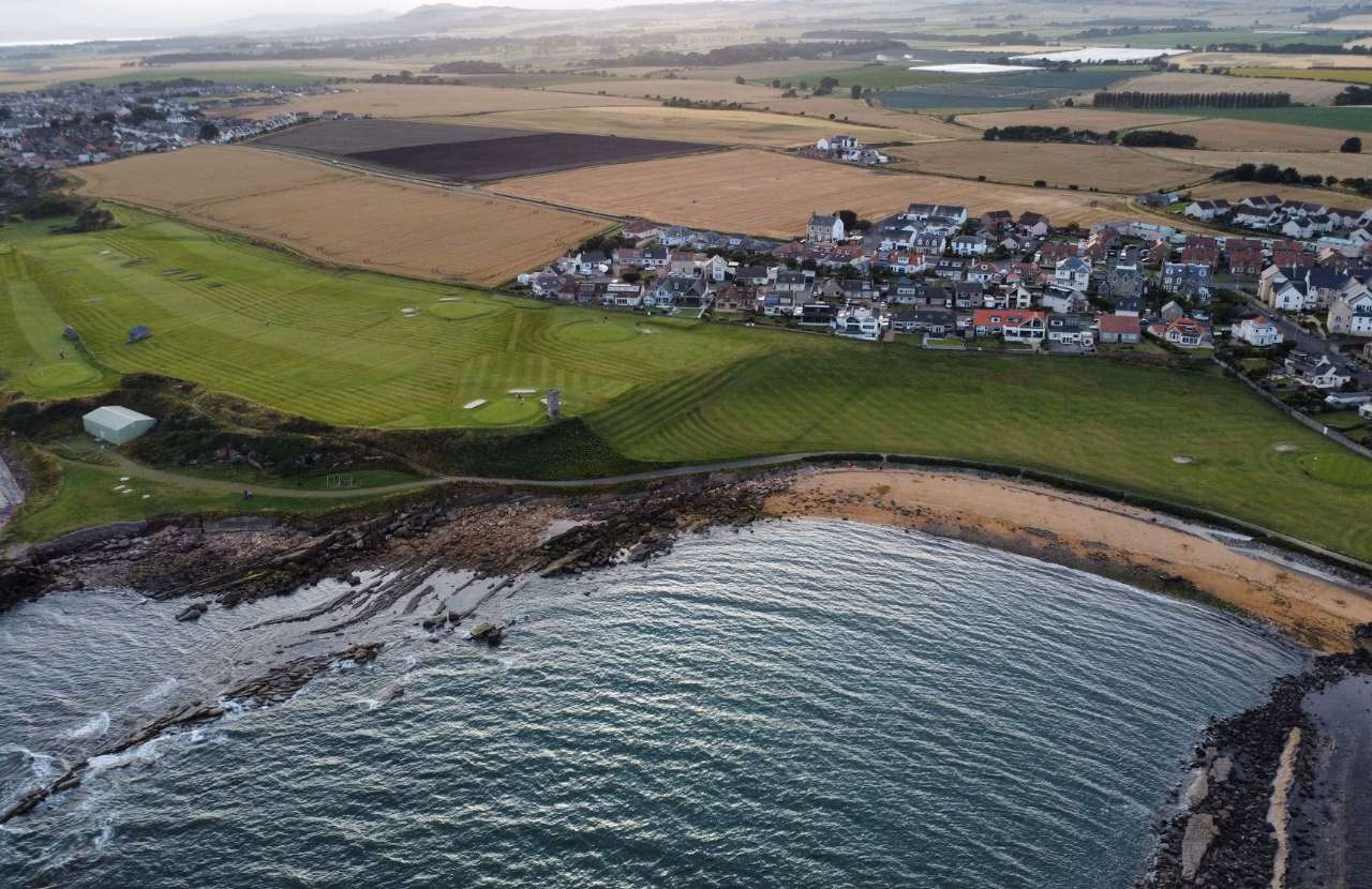 Aerial view of Anstruther Golf Club beside the shoreline and neighbouring town.