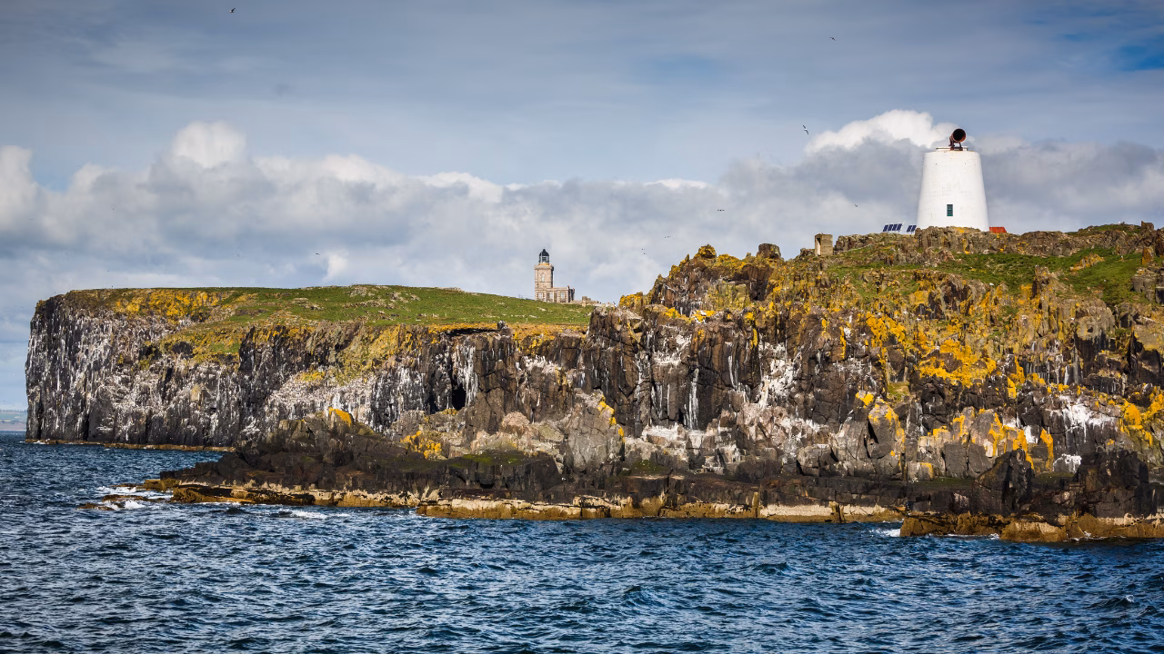 Rocky cliffs and lighthouse buildings on the Isle of May National Nature Reserve.