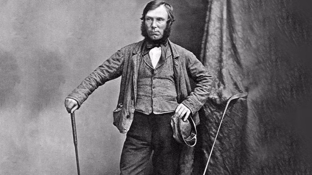 Allan Robertson holding a golf club in a studio portrait.