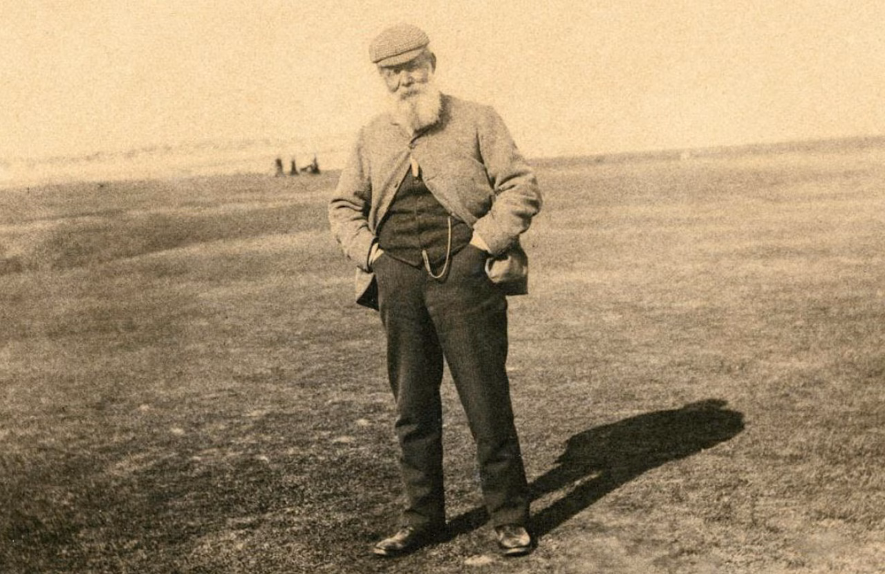 Old Tom Morris standing on a golf links.
