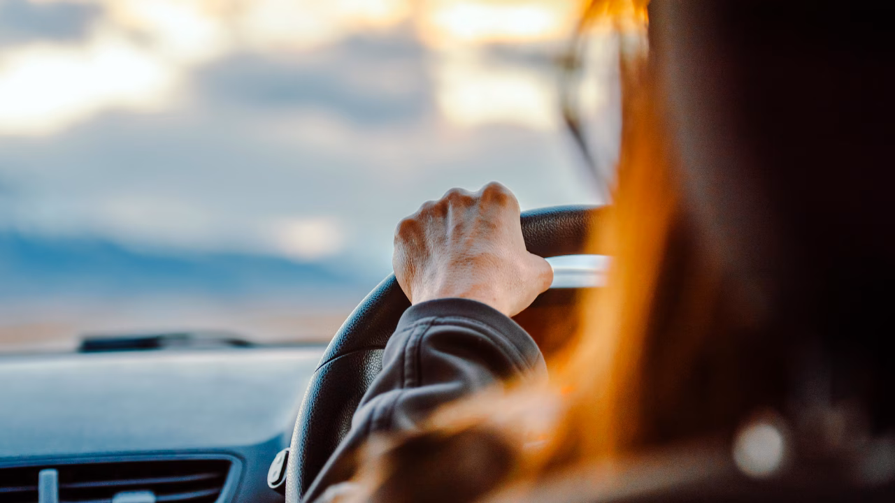 Driver holding the steering wheel during a self-drive journey.
