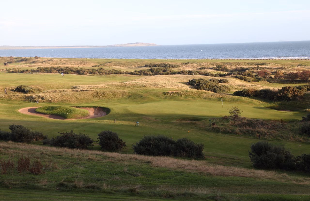 Lundin Golf Club with links greens, bunkers, and the Firth of Forth beyond.